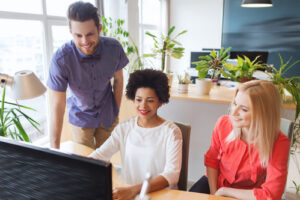 happy creative team with computer in office